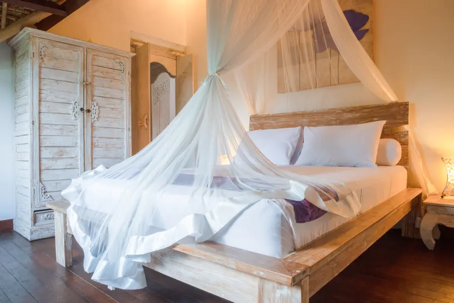 Chambre d'une villa avec lit à baldaquin et moustiquaire
