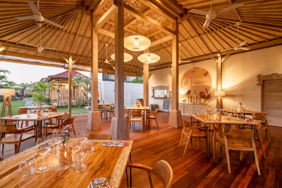 Restaurant O'zarome sous charpente balinaise, tables dressées