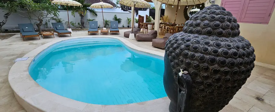 Piscine avec tête de Bouddha et parasols